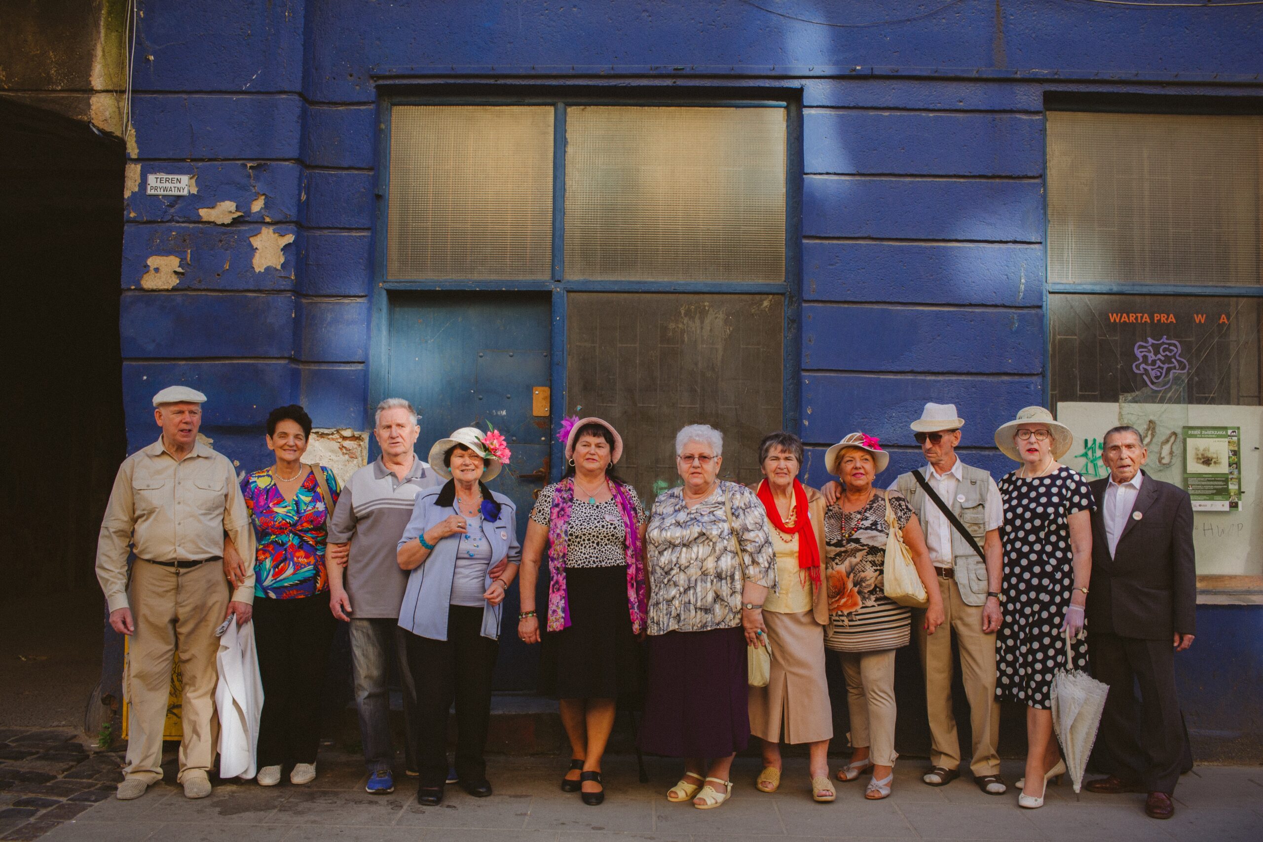 Zdjęcie. Grupa osób w starszym wieku na tle budynku.
